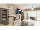 Living room featuring stone fireplace, built-in shelving, and sliding glass doors to the backyard at 3100 Pine Needle Trl, Kissimmee, FL 34746
