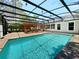 A large swimming pool featuring a screened enclosure, with pergola covered area at 3100 Pine Needle Trl, Kissimmee, FL 34746