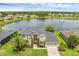 Stunning aerial view of a gray two-story home near a serene lake and fountain at 3131 Regal Darner Dr, Kissimmee, FL 34744