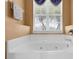 Relaxing bathroom featuring a large soaking tub, neutral color scheme, and natural light at 3131 Regal Darner Dr, Kissimmee, FL 34744