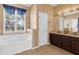 Bathroom showcasing a soaking tub, double vanity, and natural light from the large window at 3131 Regal Darner Dr, Kissimmee, FL 34744