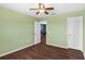 Empty bedroom featuring hardwood floors, neutral walls, a ceiling fan, and an entrance at 3131 Regal Darner Dr, Kissimmee, FL 34744