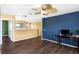 Well-lit bedroom with hardwood floors, an eye-catching ceiling fan, and multiple entrances at 3131 Regal Darner Dr, Kissimmee, FL 34744