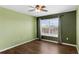 Sunlit bedroom featuring hardwood floors, neutral walls, a ceiling fan, and a large window at 3131 Regal Darner Dr, Kissimmee, FL 34744
