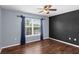 Modern bedroom with hardwood floors, a dark accent wall, and a large window for natural light at 3131 Regal Darner Dr, Kissimmee, FL 34744