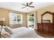 Lake view main bedroom with wood floors, large window, and dresser with mirror at 3131 Regal Darner Dr, Kissimmee, FL 34744