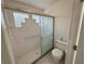 Well-lit bathroom shower with glass block window, sliding doors, and tiled walls at 3352 Hamlet Loop, Winter Park, FL 32792