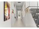 A well-lit hallway with white walls, artwork, and a glass-paneled staircase to the right at 350 Northwind Rd, Maitland, FL 32751