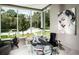 Bright office space with a glass desk, modern decor, and a large window overlooking the landscaped front yard at 350 Northwind Rd, Maitland, FL 32751