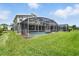 Spacious screened backyard with a private pool, lush lawn, and room to relax and entertain at 369 Ocean Course Ave, Davenport, FL 33896