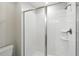 A bathroom features a white walk-in shower with glass doors and a shower head at 369 Ocean Course Ave, Davenport, FL 33896