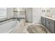 Luxurious bathroom with soaking tub, marble tile, and a double vanity at 369 Ocean Course Ave, Davenport, FL 33896