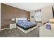 Bedroom with a white frame bed, brown accent wall, and large window at 369 Ocean Course Ave, Davenport, FL 33896