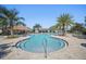Inviting community pool area with palm trees, a tiki hut, and ample seating for relaxation at 369 Ocean Course Ave, Davenport, FL 33896