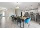 Open-concept dining room featuring a modern chandelier, tile floors, and seamless flow into the kitchen and living areas at 369 Ocean Course Ave, Davenport, FL 33896