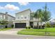Charming two-story home featuring stone accents, a two-car garage, and a well-manicured lawn with palm trees at 369 Ocean Course Ave, Davenport, FL 33896