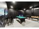 Spacious game room with a pool table, foosball, and sleek black walls for entertainment at 369 Ocean Course Ave, Davenport, FL 33896