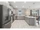 Eat-in kitchen featuring stainless appliances, gray cabinets and white countertops with bar stool seating at 369 Ocean Course Ave, Davenport, FL 33896