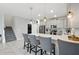 Bright eat-in kitchen featuring stainless appliances, gray cabinets, and bar seating with access to stairs at 369 Ocean Course Ave, Davenport, FL 33896
