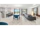 Open-concept living space with tile floors, large windows, modern furnishings, and seamless connection to dining area at 369 Ocean Course Ave, Davenport, FL 33896