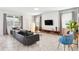 Stylish living room featuring a textured accent wall, modern furniture, and ample natural light from large windows at 369 Ocean Course Ave, Davenport, FL 33896