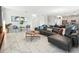 Spacious living area featuring tile floors, an open layout, and modern furnishings seamlessly connecting to the dining and kitchen areas at 369 Ocean Course Ave, Davenport, FL 33896