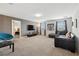 Open-concept living room features a mounted television, sofa, and lounge chair at 369 Ocean Course Ave, Davenport, FL 33896