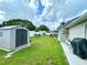 Fenced backyard with a storage shed, lush green lawn, and a grilling station at 3708 Beaver Ridge Dr, Orlando, FL 32829