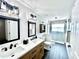 Modern bathroom featuring double sinks, quartz countertop, wood vanity, and a glass shower at 3708 Beaver Ridge Dr, Orlando, FL 32829