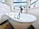 Close-up of bathroom featuring a modern tub with black fixtures and a frosted window for privacy at 3708 Beaver Ridge Dr, Orlando, FL 32829