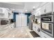 Modern kitchen featuring white cabinets, marble countertops, stainless steel appliances, and an adjacent laundry area at 3722 Neptune Dr, Orlando, FL 32804