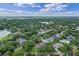 Expansive aerial view of a neighborhood with lush greenery, showcasing well-spaced homes and mature trees at 446 Alberta Dr, Winter Park, FL 32789