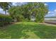The vast backyard of the property offers views of the lake, trees, and lush green grass at 446 Alberta Dr, Winter Park, FL 32789