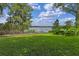 Backyard view with a lush lawn, lake view, mature trees and manicured landscaping at 446 Alberta Dr, Winter Park, FL 32789