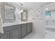 Stylish bathroom featuring a double vanity, decorative mirrors, and wallpaper at 446 Alberta Dr, Winter Park, FL 32789