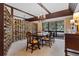 Elegant dining room with a chandelier, decorative brick wall, and large window overlooking the yard at 446 Alberta Dr, Winter Park, FL 32789
