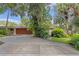 Home featuring a large driveway with mature landscaping and an attached garage at 446 Alberta Dr, Winter Park, FL 32789
