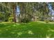 View of the front yard with lush grass, mature trees and a glimpse of the home's exterior at 446 Alberta Dr, Winter Park, FL 32789