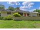 Inviting one-story home featuring a manicured lawn, brick accents, and an attractive front facade at 446 Alberta Dr, Winter Park, FL 32789