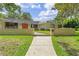Charming single-story home with well-manicured lawn, brick accents, and inviting walkway at 446 Alberta Dr, Winter Park, FL 32789