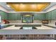 Retro kitchen with green walls featuring a brick cooking island and stainless steel appliances at 446 Alberta Dr, Winter Park, FL 32789