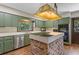 Vintage kitchen features a center cooking island with brick facade and stainless steel appliances with natural lighting at 446 Alberta Dr, Winter Park, FL 32789