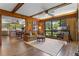 Living room featuring wood paneled walls, hardwood floors and a brick fireplace open to an adjacent dining area at 446 Alberta Dr, Winter Park, FL 32789