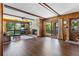 Spacious living room featuring a cozy brick fireplace, wood paneled walls and large windows overlooking a lush garden at 446 Alberta Dr, Winter Park, FL 32789