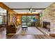 Cozy living room with hardwood floors, a brick fireplace, and large windows providing natural light and garden views at 446 Alberta Dr, Winter Park, FL 32789