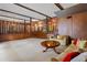 Open-concept living area featuring wood paneling, soft carpeting, and cozy seating for relaxing at 446 Alberta Dr, Winter Park, FL 32789