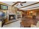 Living room with hardwood floors featuring a brick fireplace and wooden cabinet/shelving unit for optimal storage at 446 Alberta Dr, Winter Park, FL 32789
