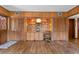 Living room with wood paneled walls and hardwood floors featuring a built-in wooden cabinet and shelving unit at 446 Alberta Dr, Winter Park, FL 32789