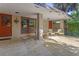 The covered patio features a brick facade, neutral furniture, and an orange entry door at 446 Alberta Dr, Winter Park, FL 32789