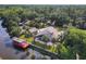 Drone shot of an estate featuring a screened pool, private dock, lush landscaping, and serene waterfront views at 448 Warrior Trl, Deltona, FL 32725